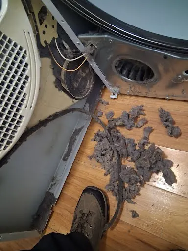 Large pile of lint removed from inside a dryer cabinet and vent