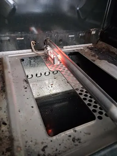 Replacement oven igniter glowing during a test after a gas oven repair