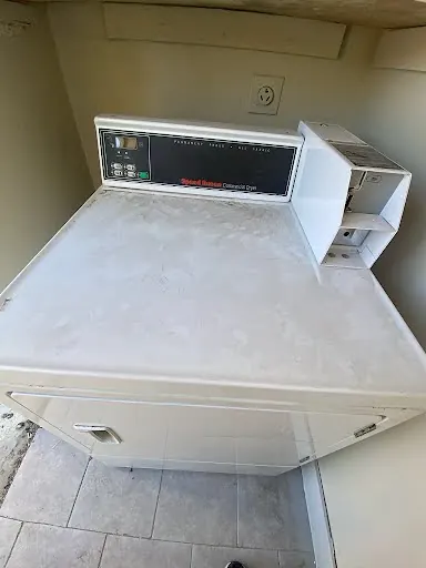 Speed Queen commercial coin-operated top-load washer in a multifamily laundry room