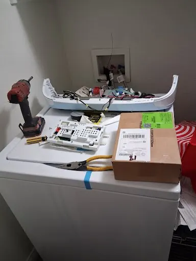New washer control board ready to install, tools set on the washer lid