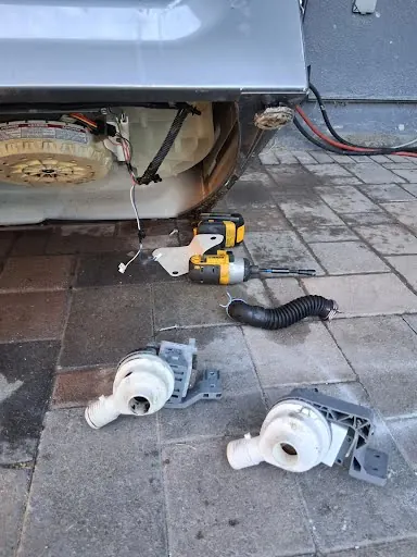 Failed washer drain pump removed next to the new pump