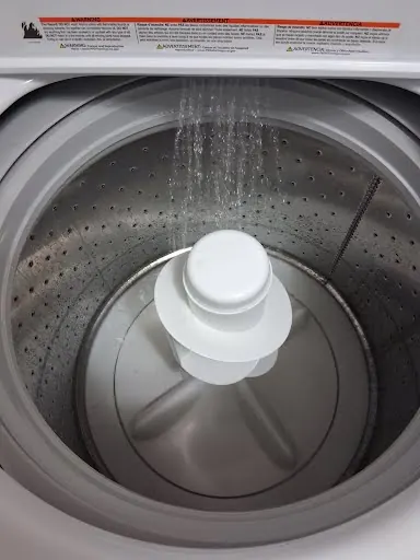 Top-load washer filling with water during a test run after repair