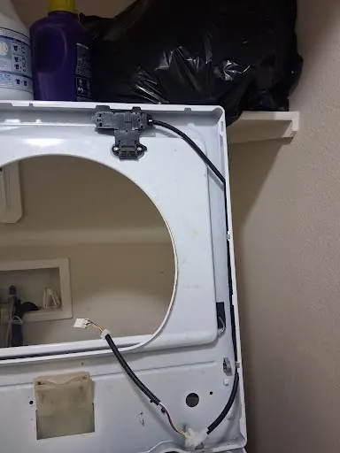 Washer top panel lifted to reach the lid lock and wiring harness
